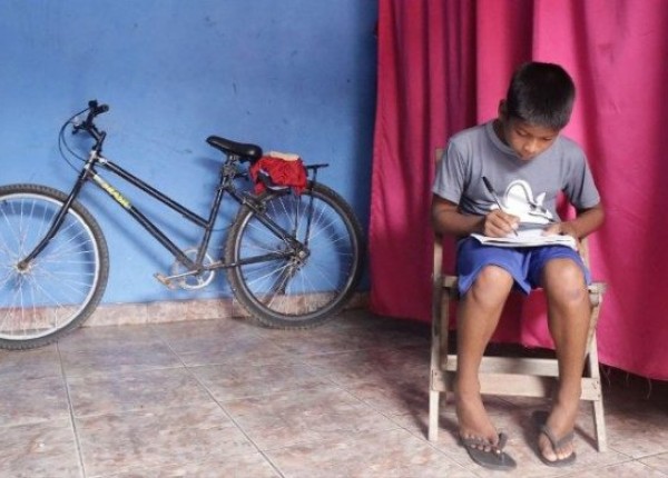 Niño pobre estudiando